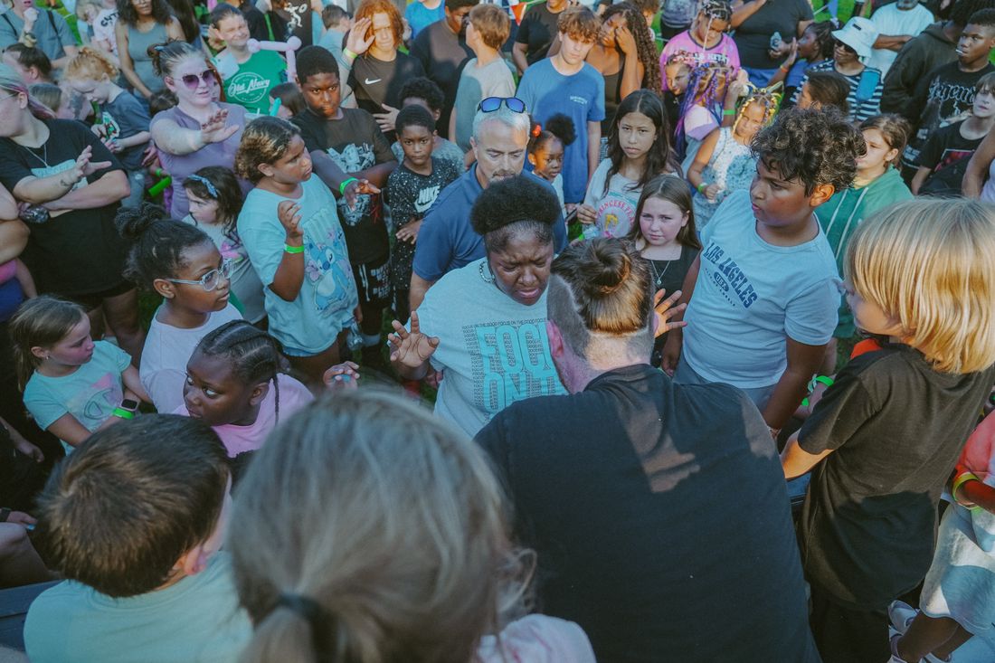 People gathered close in prayer during the altar call in Ambridge
